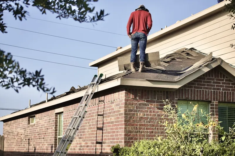 Professional roofer working on a residential roof in Roslyn Woods